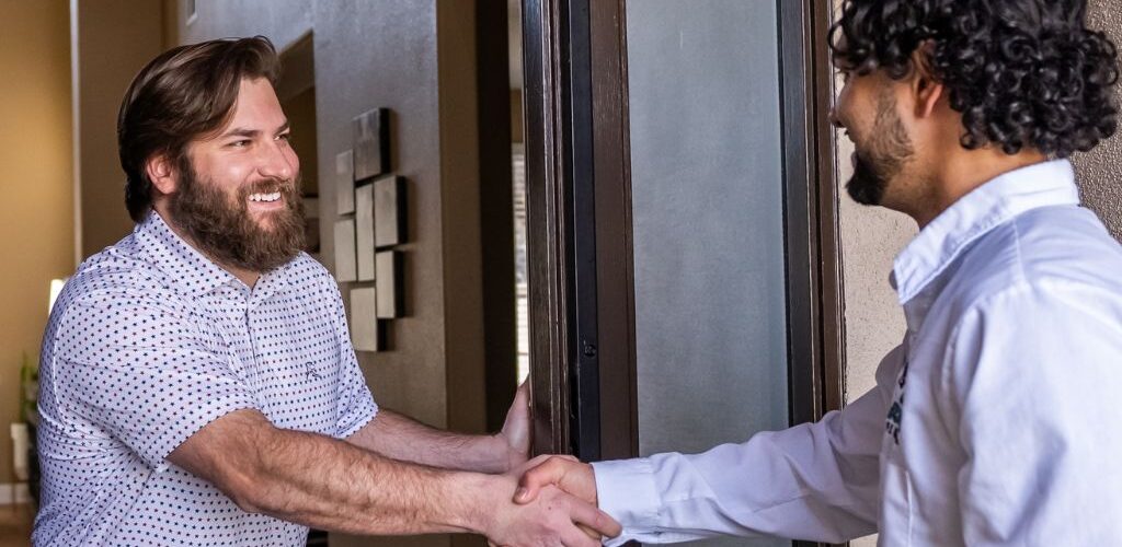 Homeowner shaking hands with service technician.
